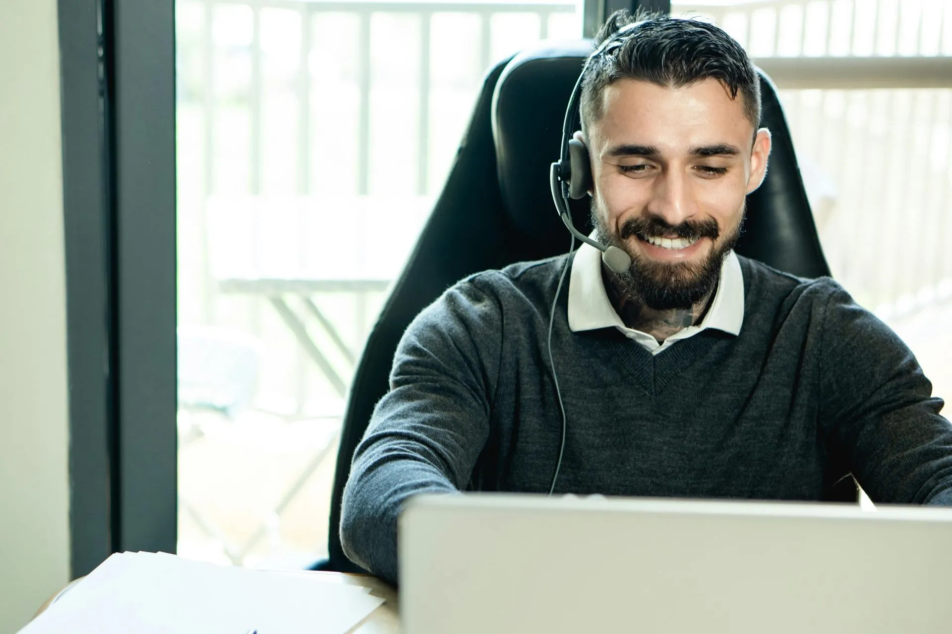 person with headset on laptop